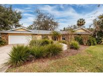 House exterior features a two-car garage and nicely landscaped lawn at 531 Garrard Dr, Temple Terrace, FL 33617