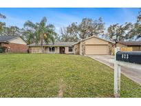 Single-story house with a stone facade, attached garage, and a well-maintained lawn at 823 Scenic Heights Dr, Brandon, FL 33511