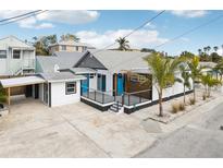Newly renovated home with a modern deck, carport, and tropical landscaping at 126 90Th Ave, Treasure Island, FL 33706