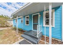 Light blue house with a front porch and landscaped yard at 1841 Overbrook Ave, Clearwater, FL 33755