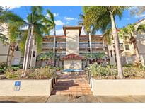 Attractive condo building with palm trees and a central fountain at 2400 Feather Sound Dr # 127, Clearwater, FL 33762