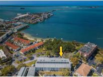 Aerial view of waterfront condo building with parking and lush landscaping at 2700 Bayshore Blvd # 6308, Dunedin, FL 34698