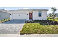 White house with gray paver driveway and landscaped lawn at 44305 Timberland Ter, Punta Gorda, FL 33982