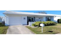 White single story home with a 1 car garage and landscaped front yard at 9130 35Th N St # 6, Pinellas Park, FL 33782