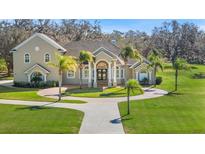 Two-story home with circular driveway and lush landscaping at 11518 Hammock Oaks Ct, Lithia, FL 33547