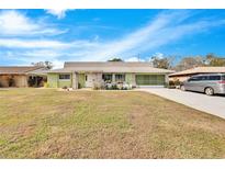Ranch style home with green exterior, stone accents and driveway at 1536 W Del Webb Blvd, Sun City Center, FL 33573