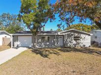 Charming ranch home with a gray exterior, white door, and attached garage at 4233 Oakfield Ave, Holiday, FL 34691