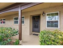 Inviting condo entryway with covered porch, lush landscaping, and a black front door at 601 N Hercules Ave # 503, Clearwater, FL 33765