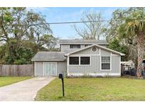 Gray two-story house with double doors and a well-maintained lawn at 6216 N 44Th St, Tampa, FL 33610