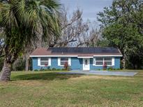 Cute blue house with solar panels and a spacious yard at 34027 Saint Joe Rd, Dade City, FL 33525