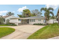 House exterior with a carport and landscaped lawn at 3435 Overlook Ne Dr, St Petersburg, FL 33703