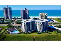 Aerial view of a condo building near the beach, with a pool and tennis courts at 1501 Gulf Blvd # 104, Clearwater Beach, FL 33767