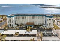 Aerial view of a waterfront condo building with parking and beautiful water views at 7 Elgin Pl # 208, Dunedin, FL 34698