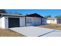 Newly renovated home featuring a modern exterior, fresh paint, and a new driveway at 10205 Cherry Creek Ln, Port Richey, FL 34668