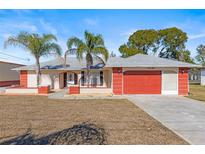 Single-story home with attached garage and palm trees at 13101 Delbarton St, Spring Hill, FL 34609