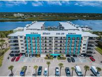 Aerial view of a waterfront condo building with parking and boat slips at 19531 Gulf Blvd # 205, Indian Shores, FL 33785
