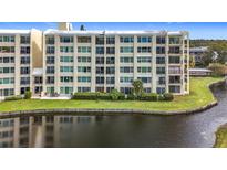 Condo building exterior with water view and lush landscaping at 225 Country Club Dr # 1611, Largo, FL 33771