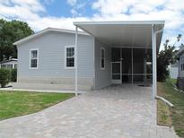 Gray mobile home with covered carport and paved driveway at 3722 Spinnaker Dr, Tampa, FL 33611