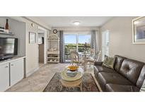 Bright living room with ocean view, leather sofa, and dining area at 4510 Gulf Blvd # 408, St Pete Beach, FL 33706
