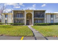 Two-story condo building with screened balconies and lush landscaping at 1433 Pine Glen Pl # D1, Tarpon Springs, FL 34688