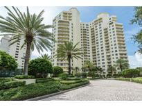 Luxury high-rise building with palm trees and landscaped grounds at 1200 Gulf Blvd # 204, Clearwater Beach, FL 33767