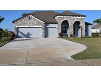 Two-story house with stone accents and three-car garage at 14914 15Th E St, Parrish, FL 34219