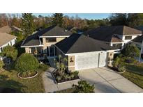 Single-story house with a two-car garage and landscaped yard at 1604 Boswell Ln, New Port Richey, FL 34655