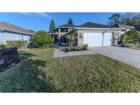 Single-story house with two-car garage and landscaped front yard at 1604 Boswell Ln, New Port Richey, FL 34655