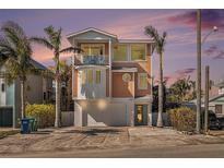 Charming three-story coastal home featuring a balcony, rounded windows, and a garage at 206 Church Ave, Bradenton Beach, FL 34217
