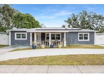 Updated home exterior with gray siding, covered porch, and landscaping at 5895 16Th N St, St Petersburg, FL 33703