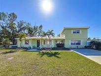 Two-story house with a green exterior, landscaping, and driveway at 6008 49Th N Ave, Kenneth City, FL 33709