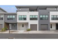 Modern two-story townhome with attached garage and neutral color palette at 8709 Palm Ranches Pl, Tampa, FL 33614