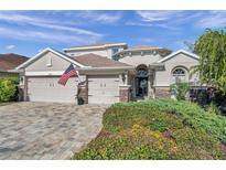 Two-story house with a three-car garage and manicured landscaping at 11550 Biddeford Pl, New Port Richey, FL 34654