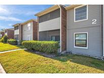 Gray condo building with brick accents, balconies, and well-maintained landscaping at 1400 Gandy N Blvd # 202, St Petersburg, FL 33702