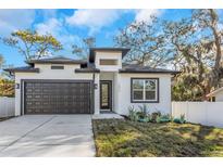 Modern house exterior with dark brown garage door and white siding at 1696 Wilmar Ave, Tarpon Springs, FL 34689