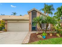 Brick home with attached garage, landscaping, and a welcoming front porch at 5450 Greyston St, Palm Harbor, FL 34685