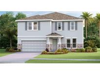 Two-story house with gray siding, stone accents, and a two-car garage at 6724 Broad River Ave, Land O Lakes, FL 34638