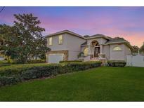 Two-story house with stone accents, landscaped lawn, and a two-car garage at 720 Sunset Dr, Tarpon Springs, FL 34689