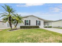 Single-story home with landscaped lawn and driveway at 7800 Kay Marie Ave, Zephyrhills, FL 33541