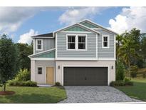 Two-story house with gray siding, dark garage door, and landscaping at 37284 Sagemoor Dr, Zephyrhills, FL 33541