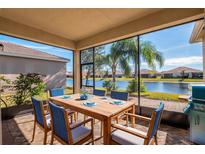 Enjoy outdoor dining on this screened patio overlooking a peaceful lake at 4846 Sandy Glen Way, Wimauma, FL 33598