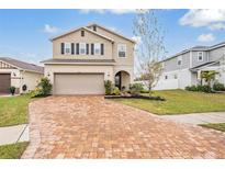 Two-story house with a brick driveway and landscaping at 7423 Northern Lights Dr, Gibsonton, FL 33534