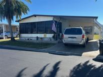 Single-wide manufactured home with carport and mature landscaping at 12501 Ulmerton Rd # 140, Largo, FL 33774