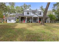 Two-story home with wrap-around porch and large yard at 19387 Hidden Oaks Dr, Brooksville, FL 34604