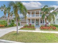 Two-story house with a neutral exterior, a large front porch, and a two-car garage at 406 Manns Harbor Dr, Apollo Beach, FL 33572