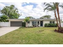 White brick ranch home with a gray garage door and manicured lawn at 5084 42Nd S St, St Petersburg, FL 33711