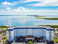Aerial view of a waterfront condo building with beautiful water and landscape views at 7 Elgin Pl # 603, Dunedin, FL 34698