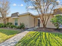 Inviting condo exterior with landscaped grounds and a walkway at 1581 Amberlea S Dr, Dunedin, FL 34698