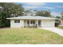 Newly renovated tan house with gray roof, covered porch, and manicured lawn at 510 N Mayo St, Crystal Beach, FL 34681