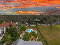 Luxury waterfront home with pool and expansive yard at sunset at 5906 N Kenneth Ave, Tampa, FL 33604